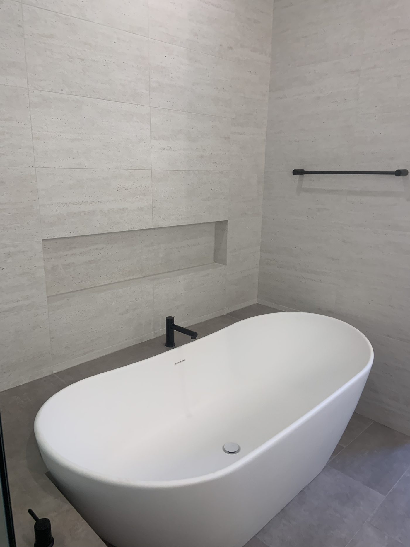 Modern bathroom remodel with freestanding soaker tub and matte black fixtures