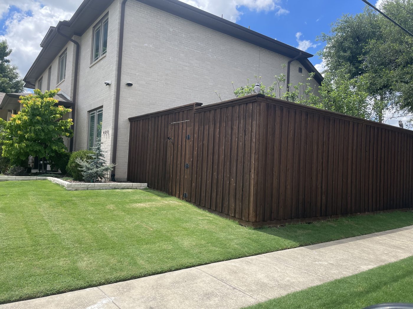 Dark-stained board-on-board privacy fence with gate in McKinney