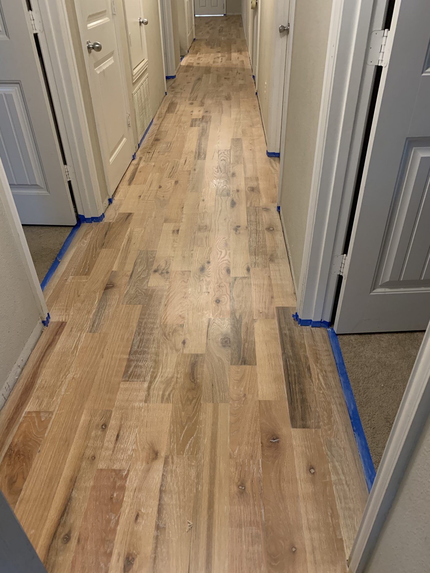 Wood-plank flooring installation in a hallway